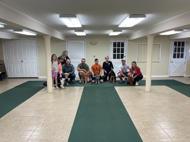 Proud dog owners with their pets at a training class graduation ceremony