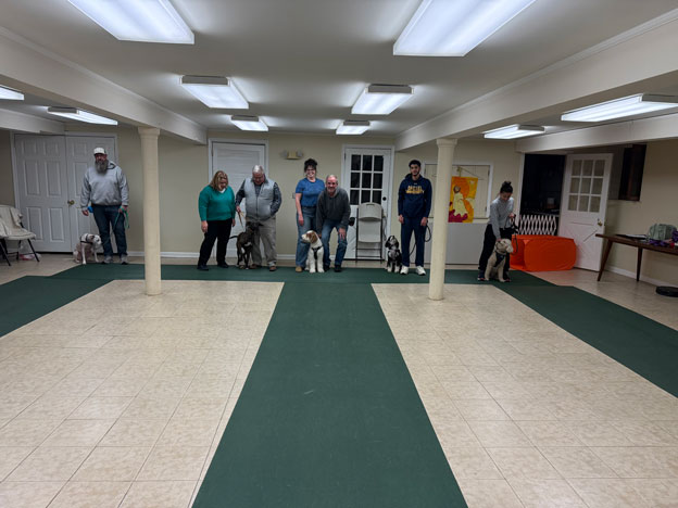 Proud dog owners with their pets at a training class graduation ceremony